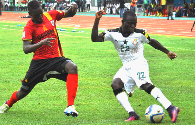  Black Stars’ Frank Acheampong (22) gains the upper hand in this midfield action with  Ugandan defender, Juuko Murushid